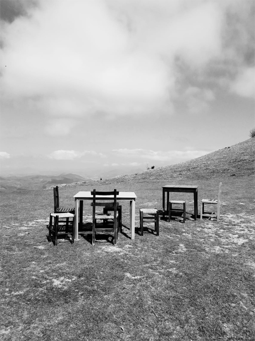 Sillas y mesas de diseño en un paisaje abierto
